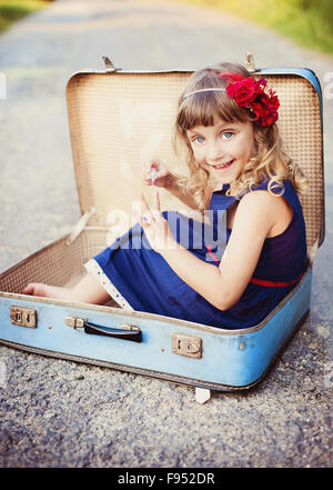 Cute little girl is having fun in the old suitcase Stock Photo