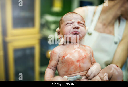 Doctor holding a beautiful baby girl few seconds after the birth Stock Photo