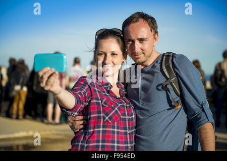 Happy young tourist couple looking at camera and taking selfie, smiling and having fun on Europe vacation trip in Barcelona, Spa Stock Photo