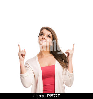 Beautiful young woman pointing upwards, isolated over a white background Stock Photo