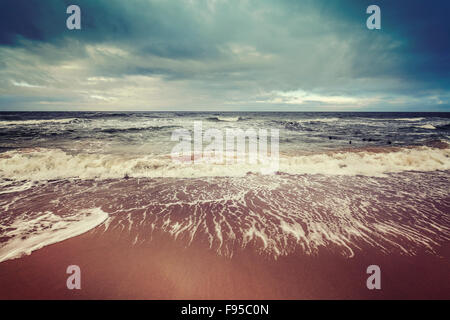 Vintage toned stormy sky over rough sea, calm before the storm concept. Stock Photo