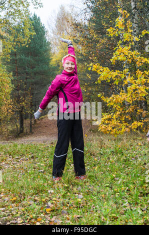 The woman is engaged in aerobics in the autumn park Stock Photo
