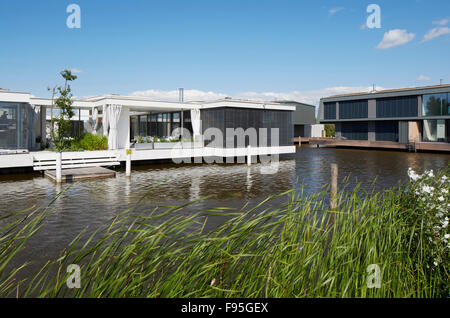 Housing development at Lake Neusiedl, Neusiedl am See, Burgenland, Austria. View across the water to the contemporary lakeside housing development. Extensive glass exterior walls. Stock Photo