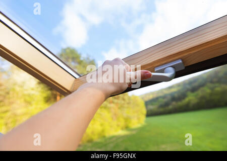Beautiful nature view through roof skylight window in attic room. Stock Photo