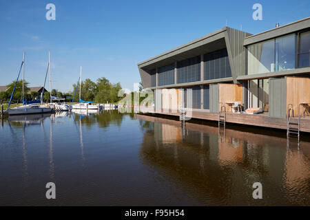 Housing development at Lake Neusiedl, Neusiedl am See, Burgenland, Austria. Yachts moored across the lake opposite the contemporary waterside housing development at Neusiedl am See, Burgenland, Austria. Stock Photo