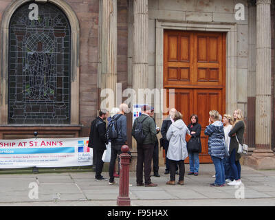 People going on a guided tour of Manchester meeting at Saint Annes church in St Annes Square. Stock Photo