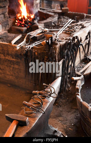 Anvil and fire pit at the Green Family Forge, a living history blacksmith museum in Trinity, Newfoundland. The forge dates back Stock Photo