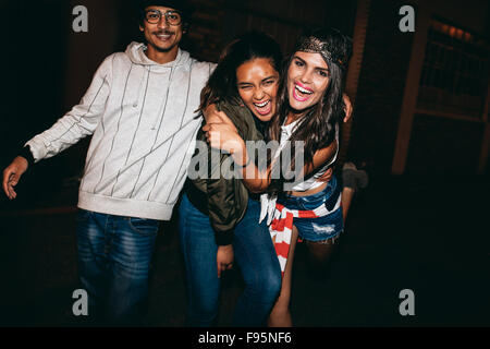 Portrait of three young friends having fun together in outdoor party. Crazy young best friends hanging out. Stock Photo