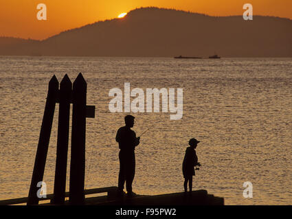 Silouettes of people fishing at sunset, San Juan Islands, WA Stock Photo