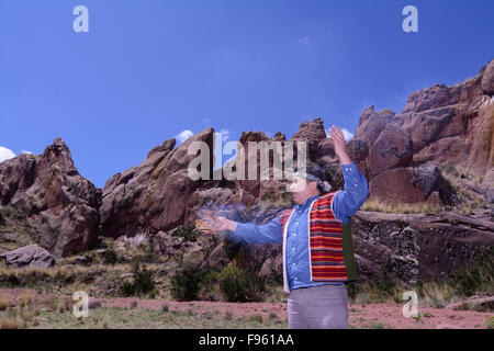 Peruvian shaman conducts ritual at  Amaru Muru, a mysterious ‘doorway’ carved into a rock face, called the gateway to the 4th Stock Photo