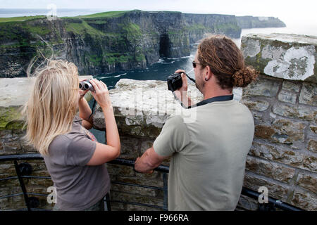 Young adults on vacation taking photographs. Cliffs of Moher, Ireland Stock Photo