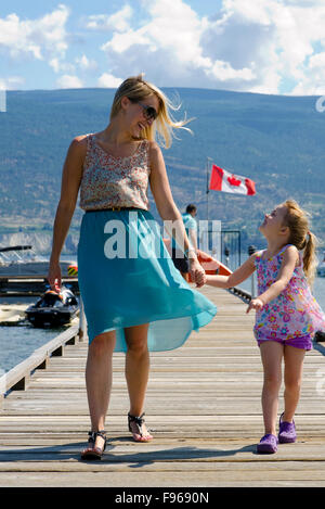 Mother and young daughter enjoy a warm summer afternoon walk in Summerland at the Waterfront Resort, in the South Okanagan Stock Photo