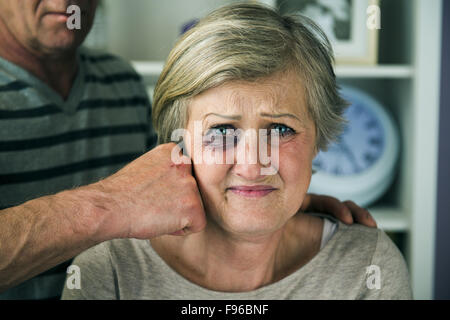 Portrait of woman victim of domestic violence. Man abusing senior woman with black eye- Stock Photo
