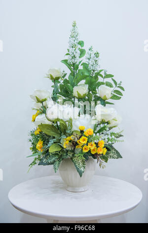 Artificial flowers bouquet in vase on the table Stock Photo