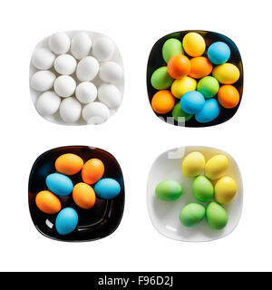 Four square plates with painted colorful Easter eggs. Colored eggs on a black and white dishes. Isolated on white background. To Stock Photo