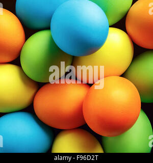Close-up of brightly colored Easter eggs. Easter background. Top view. Stock Photo