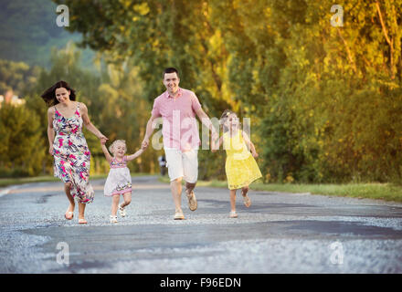Happy family having fun during the walk on the road Stock Photo