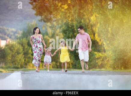 Happy family having fun during the walk on the road Stock Photo