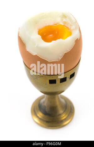 Egg in old brass cup isolated on white Stock Photo