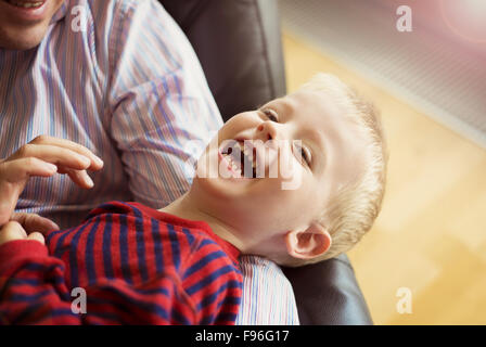 Little boy relaxing at home with his father Stock Photo