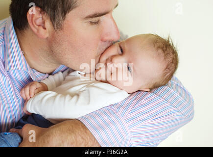 Cute newborn baby boy relaxing at home with his father Stock Photo