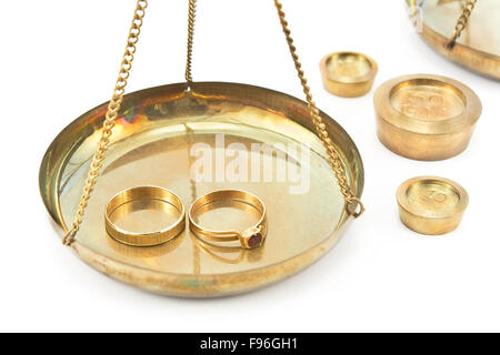 Balance scales with golden wedding rings isolated on white Stock Photo