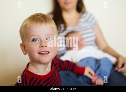 Cute little boy and his mother with his baby brother at the background Stock Photo