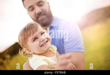 Hipster father playing with his little daughter in the green park. Stock Photo