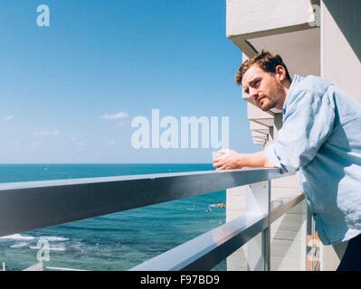 Man Looking Away While Leaning On Railing