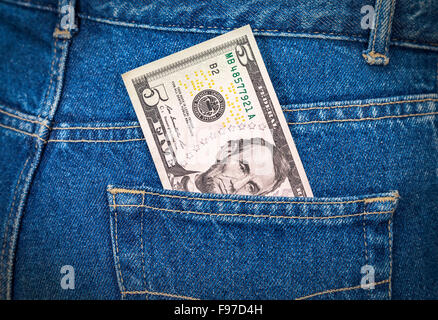 Five dollars bill sticking out of the blue jeans pocket Stock Photo