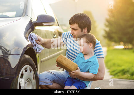 Young father with his little son washing car Stock Photo