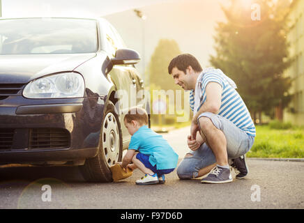 Young father with his little son washing car Stock Photo