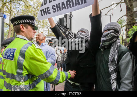 London, UK. 14th December, 2015. File Images from 18th April 2014: British-based Islamist Nadir Syed found guilty of murder plot. Seen here (Right, in headscarf and green/grey jacket) during a clash with police and far right protest groups outside Regents Park Mosque in London Credit:  Guy Corbishley/Alamy Live News Stock Photo