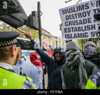 London, UK. 14th December, 2015. File Images from 18th April 2014: British-based Islamist Nadir Syed found guilty of murder plot. Seen here (in headscarf and green jacket) during a clash with police and far right protest groups outside Regents Park Mosque in London Credit:  Guy Corbishley/Alamy Live News Stock Photo