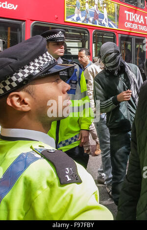 London, UK. 14th December, 2015. File Images from 18th April 2014: British-based Islamist Nadir Syed found guilty of murder plot. Seen here (right, in headscarf) during a clash with police and far right protest groups outside Regents Park Mosque in London Credit:  Guy Corbishley/Alamy Live News Stock Photo