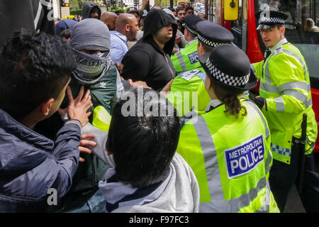 London, UK. 14th December, 2015. File Images from 18th April 2014: British-based Islamist Nadir Syed found guilty of murder plot. Seen here (left, in headscarf) during a clash with police and far right protest groups outside Regents Park Mosque in London Credit:  Guy Corbishley/Alamy Live News Stock Photo