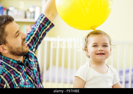 happy father and his little daughter playing with various buttons at ...