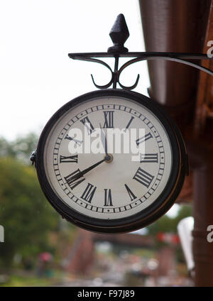 Classic vintage clock at old railway station with rain on clock face Stock Photo