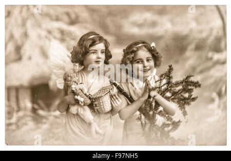 Angel girls with white wings, toys and christmas tree. Vintage picture with original film grain and blur Stock Photo