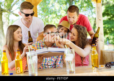 Group of happy friends drinking and eating pizza in pub garden Stock Photo