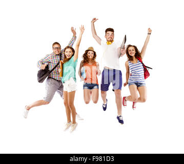 Group of happy young teenager students standing and smiling with books and bags isolated on white background.
