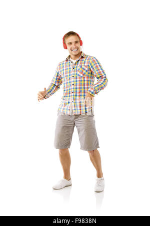 Portrait of a handsome young man dancing and listening music, isolated on white background Stock Photo