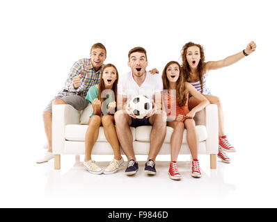 Group of happy young people sitting on sofa and holding soccer ball, isolated on white background. Best friends Stock Photo