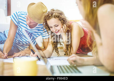 Group of young students studying together and preparing for exams in home interior Stock Photo