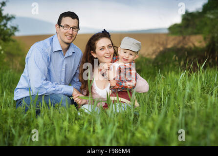 Happy family playing with son on the meadow Stock Photo
