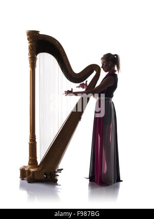 Silhouette of elegant woman in dress playing the harp, isolated on white background Stock Photo