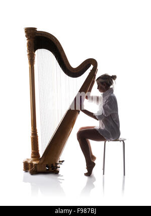 Silhouette of woman playing the harp, isolated on white background Stock Photo