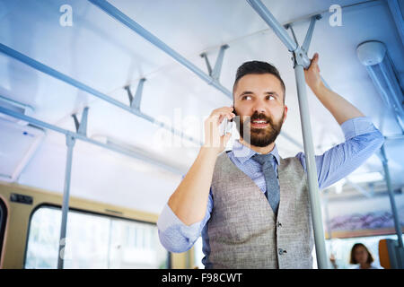 Handsome hipster modern man calling by mobile phone in tram Stock Photo