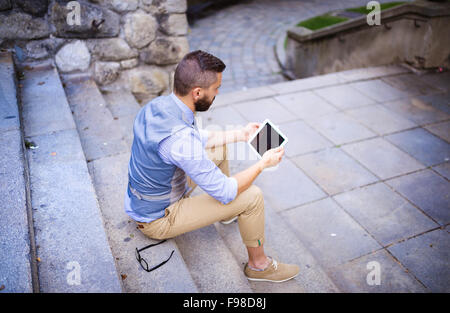 Handsome hipster modern businessman using digital tablet in the city Stock Photo