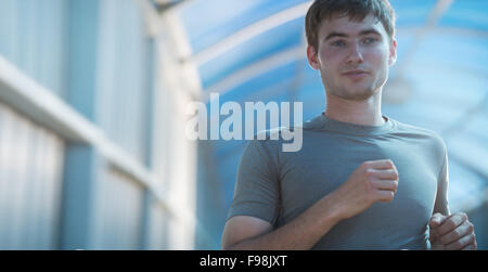 Runner athlete running on road in city. Man fitness sunrise jogging workout wellness concept. Stock Photo